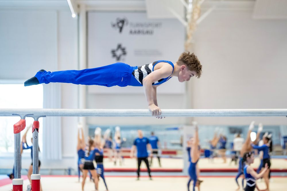 Junger Turner senkrecht an der Barre